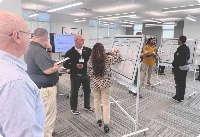 Workshop participants working at rolling whiteboards in the training center